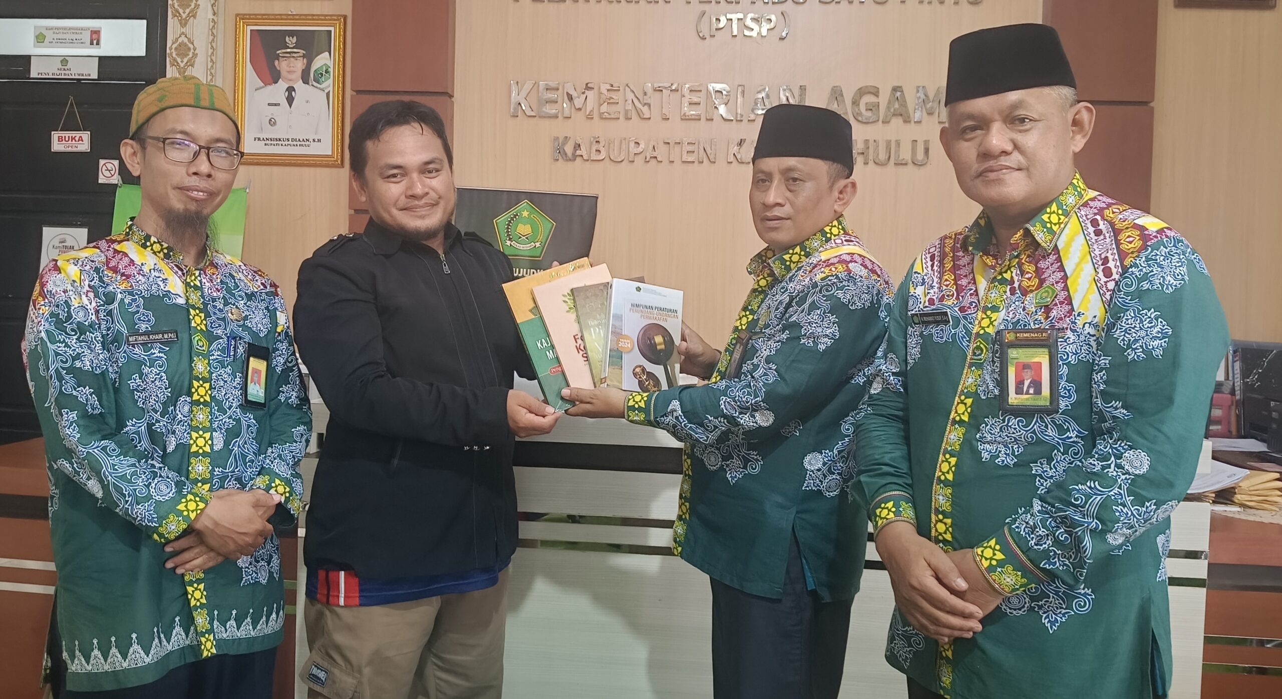 Kepala Kemenag Kapuas Hulu Mad Rais saat menyerahkan bantuan buku kepada pengurus Masjid Al Iklas Desa Mujan Kecamatan Boyan Tanjung
