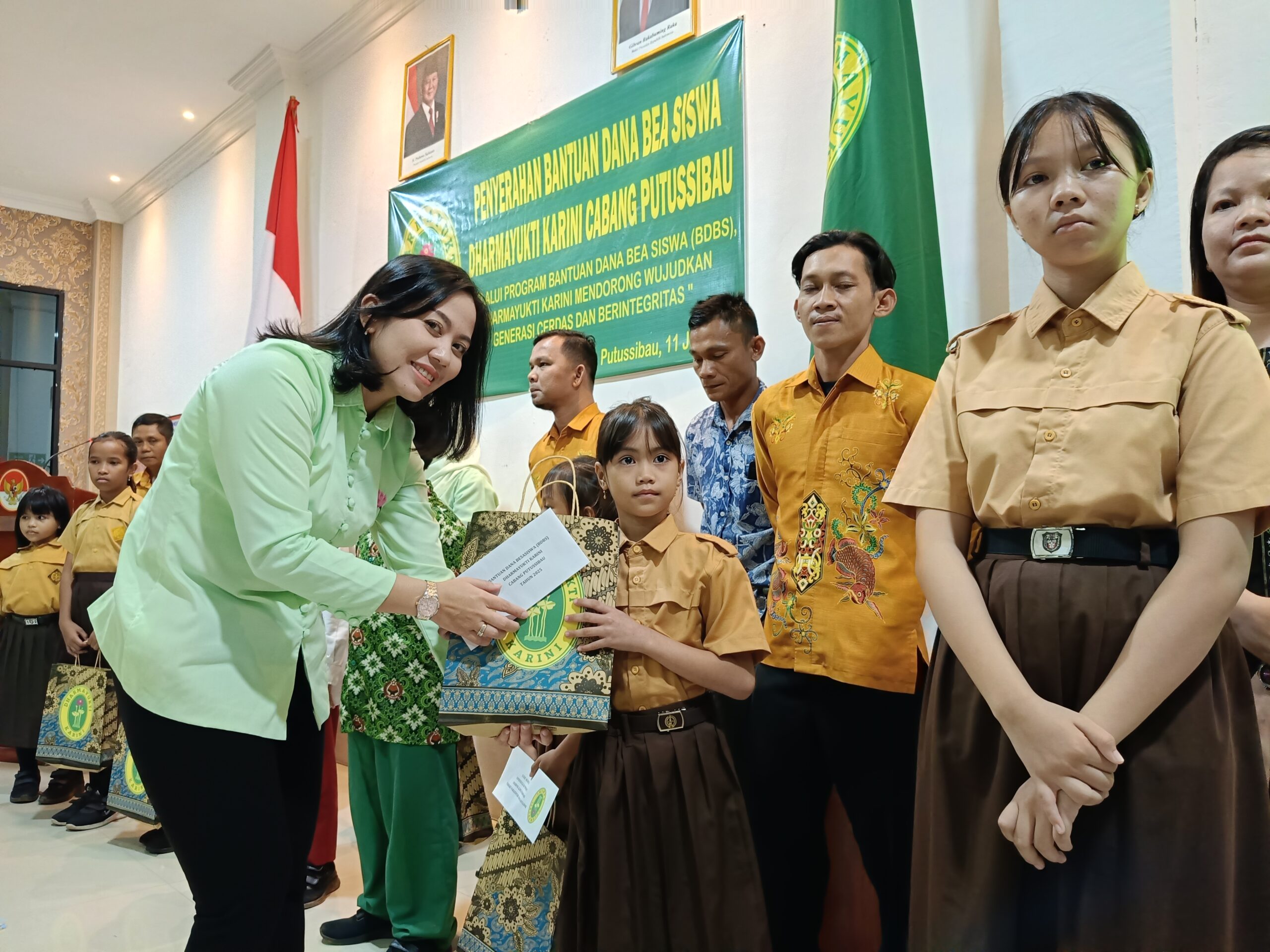 Ketua DYK Cabang Putussibau Yuliana Isnawati saat menyalurkan beasiswa kepada siswa