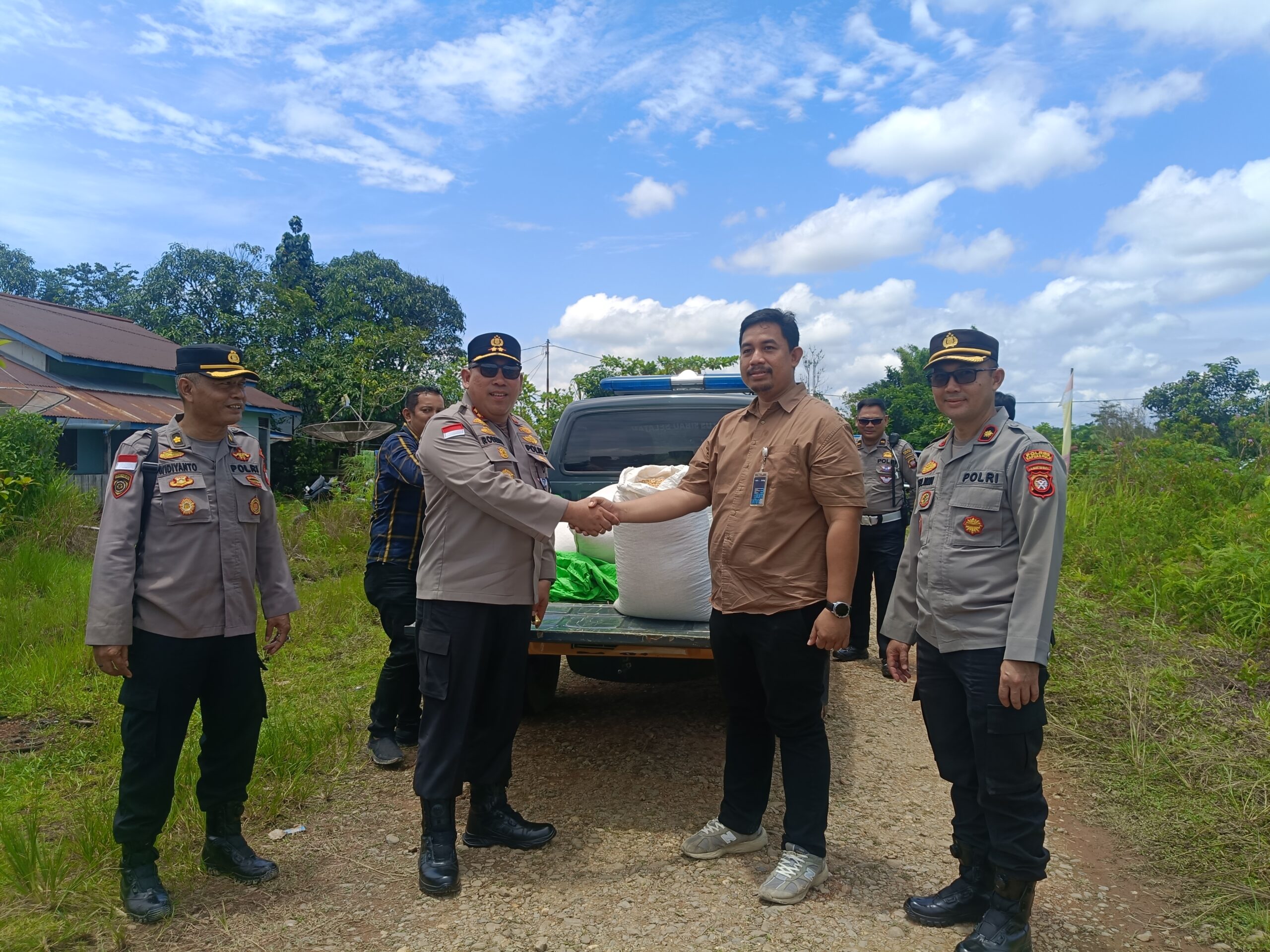 Kapolres Kapuas Hulu AKBP Roberto Aprianto Uda saat menyerahkan jagung hasil panen petani binaan mereka kepada Bulog Putussibau 